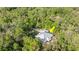 An aerial view of a single Gathering house with a lush green wooded area surrounding at 2030 Waterford Estates Dr, New Smyrna Beach, FL 32168
