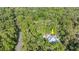 An aerial view of a single Gathering house with a lush green wooded area surrounding at 2030 Waterford Estates Dr, New Smyrna Beach, FL 32168