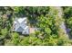 Aerial view of a home with beautiful landscaping, a driveway and surrounded by trees at 2030 Waterford Estates Dr, New Smyrna Beach, FL 32168