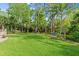 Expansive backyard with lush green grass, mature trees, and landscaped garden, great for outdoor activities at 2030 Waterford Estates Dr, New Smyrna Beach, FL 32168