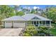 Charming home featuring a metal roof, three-car garage, and a delightful front porch with beautiful landscaping at 2030 Waterford Estates Dr, New Smyrna Beach, FL 32168