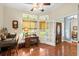 Bright office space featuring hardwood floors, built-in desk, and views of the landscaped front yard at 2030 Waterford Estates Dr, New Smyrna Beach, FL 32168