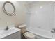 Well-lit bathroom features white tile, a bathtub, and a vanity at 211 S Delaware Ave, Deland, FL 32720