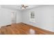 Cozy bedroom featuring hardwood floors, a ceiling fan, and natural light from the window at 211 S Delaware Ave, Deland, FL 32720