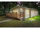 Inviting single-story home features a cozy wooden porch and lush green lawn at twilight at 211 S Delaware Ave, Deland, FL 32720