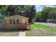 Charming single-story home with a cozy front porch and well-maintained lawn, nestled among mature trees at 211 S Delaware Ave, Deland, FL 32720