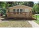 Inviting single-story home with a large wooden porch and well-maintained lawn at 211 S Delaware Ave, Deland, FL 32720