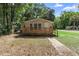 Cozy home with inviting front porch and light colored siding, surrounded by lush greenery at 211 S Delaware Ave, Deland, FL 32720