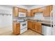 Practical kitchen with wood cabinets, white appliances, and a double sink setup at 211 S Delaware Ave, Deland, FL 32720