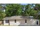 Shows the rear exterior of a single-story home with light siding and windows, and a doorway at 211 S Delaware Ave, Deland, FL 32720