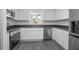 Kitchen features stainless steel appliances, light gray countertops, white cabinets and gray floors at 2145 8Th Ave, Deland, FL 32724