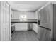 Bright kitchen features stainless steel appliances, white cabinets, and durable gray flooring at 2145 8Th Ave, Deland, FL 32724