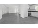Open-concept living room flowing into kitchen area with gray wood-look flooring and white walls at 2145 8Th Ave, Deland, FL 32724