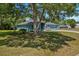 Charming single-story home with a blue exterior, mature trees, and a well-maintained front yard at 2150 Deck Ct, Deltona, FL 32738