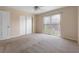This bedroom features carpeted floors, a ceiling fan, neutral walls, and sliding glass doors to a balcony at 2200 S Palmetto Ave # B060, Daytona Beach, FL 32119