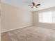 Spacious bedroom featuring a ceiling fan, carpeted floors, and natural light at 2200 S Palmetto Ave # B060, Daytona Beach, FL 32119