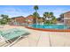 Community pool with lounge chairs surrounded by palm trees and brick apartment buildings at 2200 S Palmetto Ave # B060, Daytona Beach, FL 32119