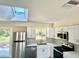 Bright kitchen with stainless steel appliances, a skylight and white cabinets at 249 Citra St, De Leon Springs, FL 32130