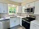 Well-lit kitchen with stainless steel appliances and white cabinetry at 249 Citra St, De Leon Springs, FL 32130