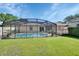 Backyard features include a screened in pool, a patio and a green lawn at 257 Deleon Rd, Debary, FL 32713