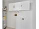 Utility room featuring a modern hot water tank and upper storage cabinets at 257 Deleon Rd, Debary, FL 32713