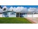 Charming single-story home with a lush green lawn and a classic blue exterior at 2573 W Coral Way, Daytona Beach, FL 32118