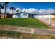 Inviting home featuring a well-maintained lawn, beautiful blue exterior, and palm trees at 2573 W Coral Way, Daytona Beach, FL 32118
