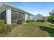 Spacious backyard features a screened patio, lush lawn, and privacy hedges, perfect for relaxation at 262 Coral Reef Way, Daytona Beach, FL 32124