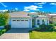Charming single-story home featuring a paver driveway and two-car garage on a sunny day at 262 Coral Reef Way, Daytona Beach, FL 32124