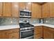 Kitchen featuring a stainless steel range, microwave, and a mosaic tile backsplash at 262 Coral Reef Way, Daytona Beach, FL 32124
