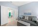 Living room with a grey couch, adjacent to another office space through a doorway at 262 Coral Reef Way, Daytona Beach, FL 32124