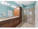 A bright main bathroom with a double vanity, granite counters, and glass shower at 262 Coral Reef Way, Daytona Beach, FL 32124