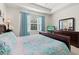 A bright main bedroom with a tray ceiling, blue curtains and dark wood furniture at 262 Coral Reef Way, Daytona Beach, FL 32124