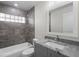 Bathroom with gray vanity, granite counters, gray tiled shower with glass block window at 266 Buford Ave, Orange City, FL 32763