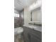 Bathroom with gray vanity, granite counters, gray tiled shower with glass block window at 266 Buford Ave, Orange City, FL 32763