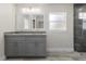 A bathroom with double sinks, granite countertops, gray vanity and a glass shower at 266 Buford Ave, Orange City, FL 32763