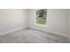 Bright bedroom features wood-look tile flooring and a window with green yard view at 266 Buford Ave, Orange City, FL 32763