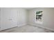 Bright bedroom features wood-look tile and a window overlooking construction and greenery at 266 Buford Ave, Orange City, FL 32763