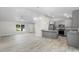 Open-concept kitchen and living room featuring stainless steel appliances, gray cabinetry, and gorgeous tile floors at 266 Buford Ave, Orange City, FL 32763