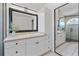 Bright bathroom features white cabinets, neutral countertops, a large mirror, and a glass-enclosed shower at 2704 Lancaster Ct, Apopka, FL 32703
