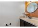 Modern powder room with vanity, round mirror, and neutral walls at 2704 Lancaster Ct, Apopka, FL 32703