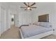 Cozy bedroom features neutral carpet, a modern ceiling fan, and a large headboard with side tables at 2704 Lancaster Ct, Apopka, FL 32703