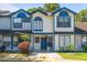 Charming townhome with colorful blue trim, updated windows, and manicured front yard at 2704 Lancaster Ct, Apopka, FL 32703