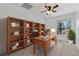 Office featuring built-in wooden shelves, a window with natural light, and a wooden desk with plants at 2704 Lancaster Ct, Apopka, FL 32703