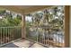 Covered balcony with a white metal railing and a view of the trees and parking lot at 2706 Oak Trail Run # 6, Port Orange, FL 32127