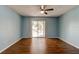 Cozy living room featuring sleek wood floors, a ceiling fan, and sliding glass doors to a balcony at 2706 Oak Trail Run # 6, Port Orange, FL 32127