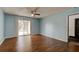 Living room boasts with wood floors, a ceiling fan, and a sliding glass door to a balcony at 2706 Oak Trail Run # 6, Port Orange, FL 32127