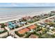 An aerial view showcases coastal living with charming homes near a beautiful beach at 2982 S Atlantic Ave, New Smyrna Beach, FL 32169