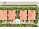 Aerial view of a condo community with a shared pool, manicured lawns, and tiled roofs, providing a serene escape at 2982 S Atlantic Ave, New Smyrna Beach, FL 32169