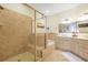 Well lit beige tile bathroom featuring a glass-enclosed shower, soaking tub and double vanity at 2982 S Atlantic Ave, New Smyrna Beach, FL 32169